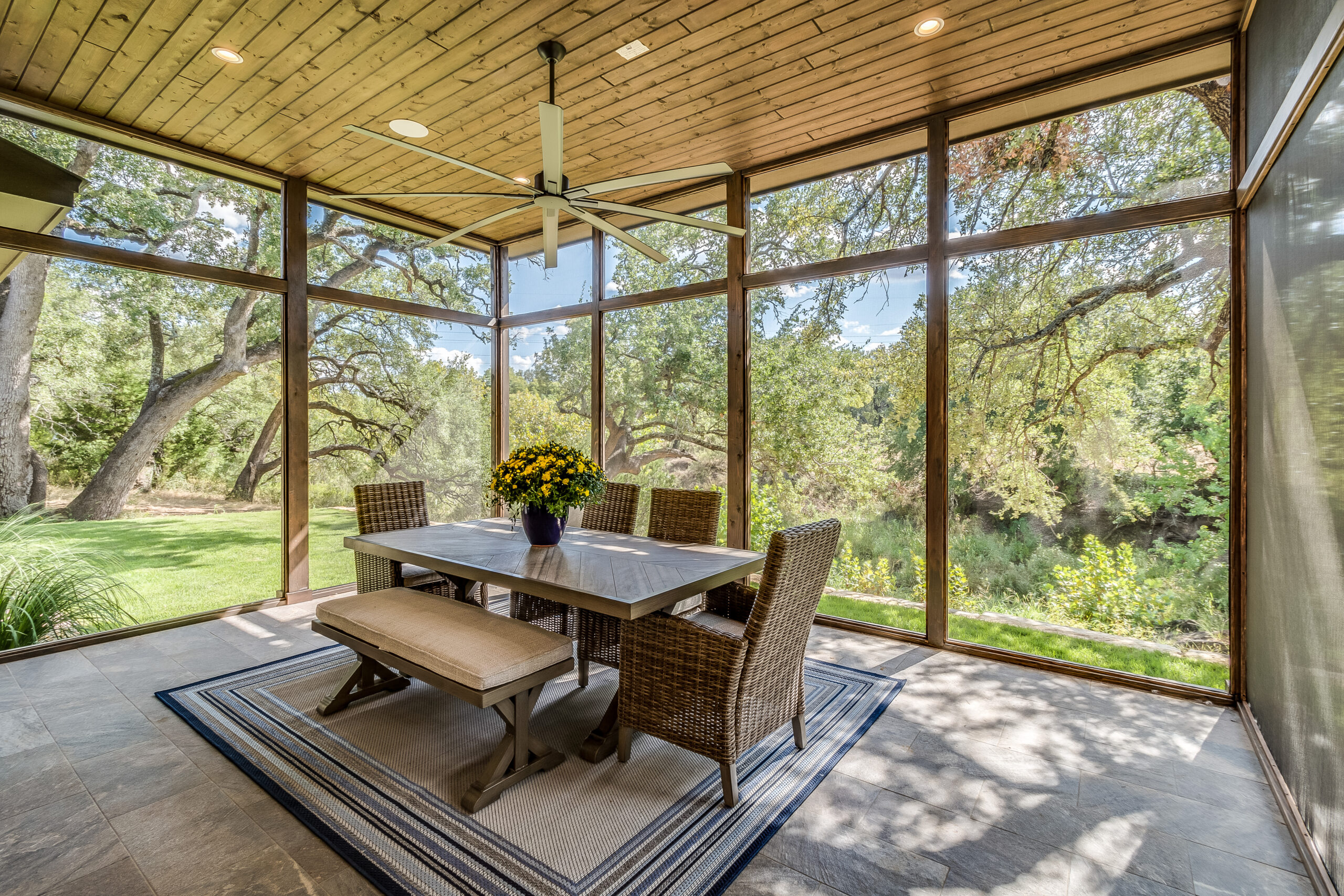 The interior of a room with wooden roof panels & glass walls.