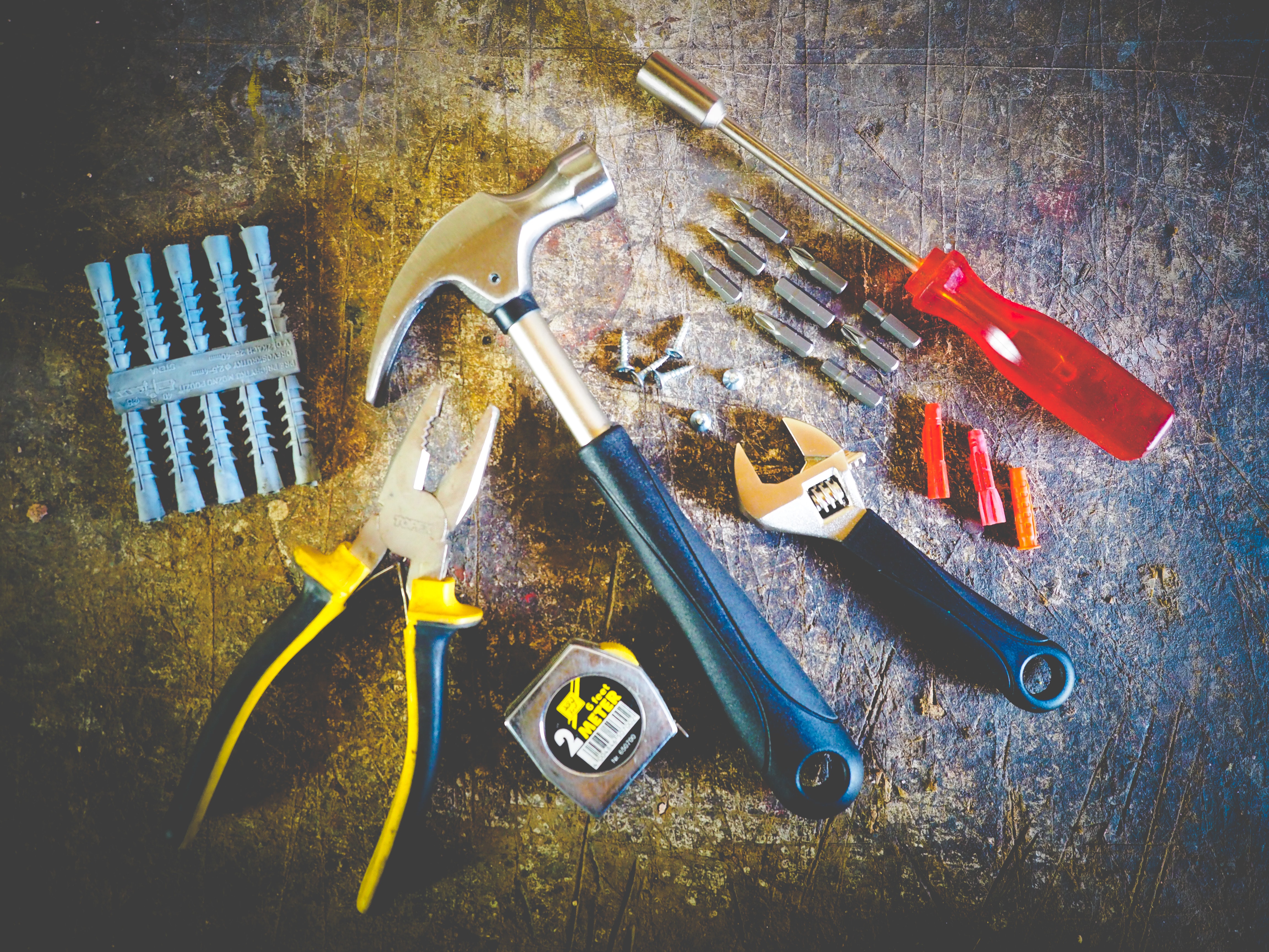 Tools including a hammer, screwdriver, measuring tape, etc placed on the floor